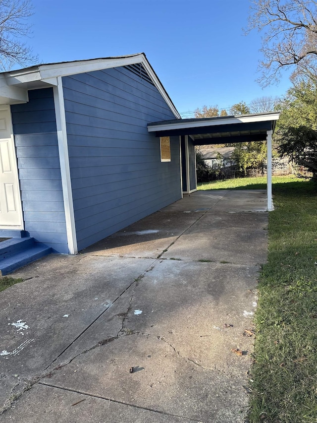 view of side of home with driveway and an attached carport