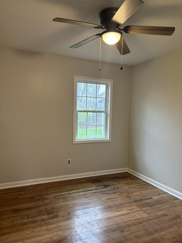 spare room featuring dark wood-style floors and baseboards