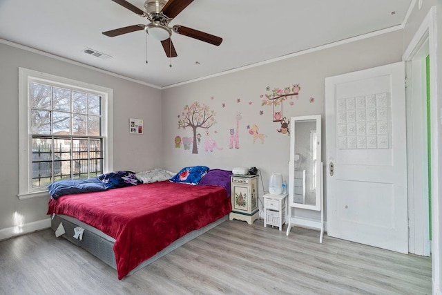 bedroom with light wood finished floors, ornamental molding, and visible vents