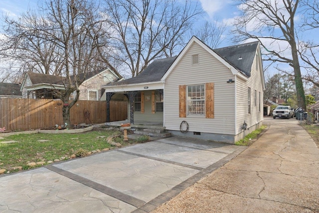 bungalow-style house featuring covered porch and fence