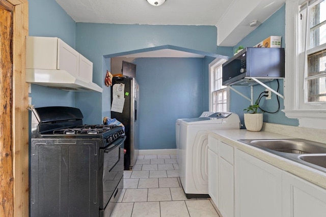 kitchen with black gas range, under cabinet range hood, white cabinets, light countertops, and stainless steel fridge with ice dispenser