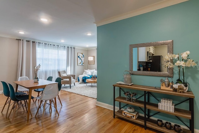 dining space with baseboards, recessed lighting, wood finished floors, and crown molding