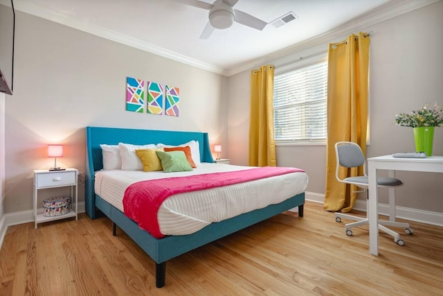 bedroom featuring ornamental molding, wood finished floors, visible vents, and baseboards