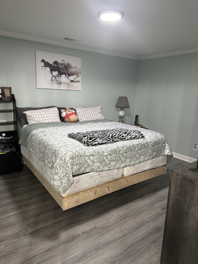 bedroom featuring visible vents, dark wood finished floors, and ornamental molding