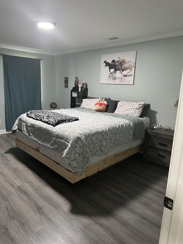 bedroom featuring ornamental molding, visible vents, and wood finished floors