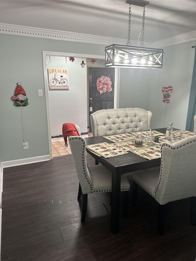 dining area featuring baseboards, ornamental molding, and wood finished floors