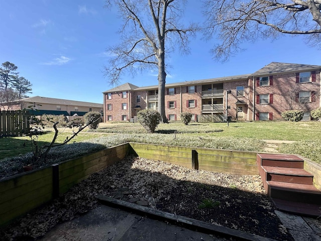 view of property's community with a yard and fence