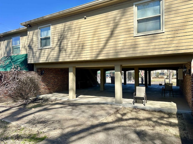 exterior space featuring brick siding and a patio