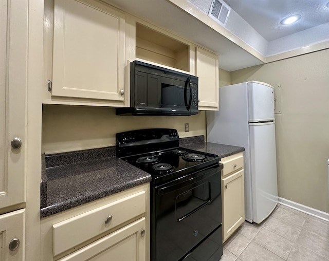 kitchen with light tile patterned floors, visible vents, dark countertops, cream cabinets, and black appliances