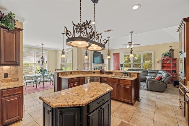 kitchen featuring a center island, stainless steel appliances, visible vents, hanging light fixtures, and open floor plan