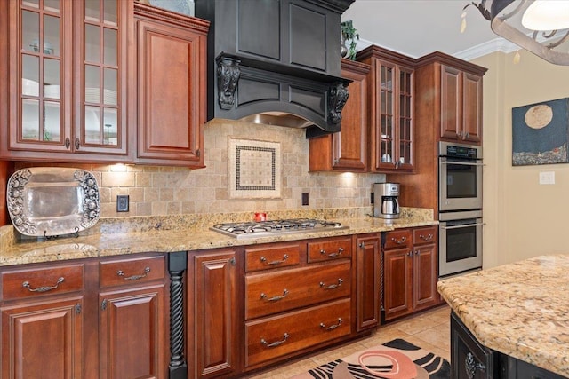 kitchen with light tile patterned floors, stainless steel appliances, backsplash, and glass insert cabinets