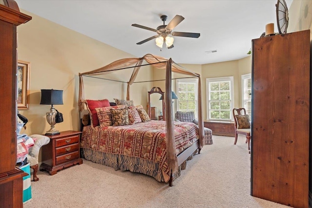 bedroom with light carpet, ceiling fan, and visible vents