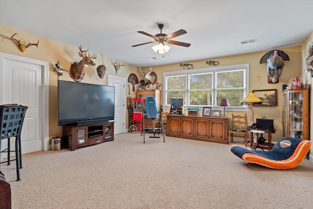 office space featuring ceiling fan, visible vents, and light colored carpet