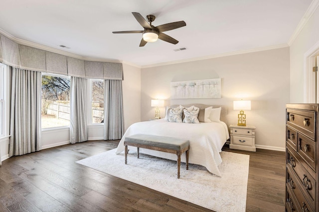 bedroom featuring baseboards, dark wood-type flooring, visible vents, and crown molding