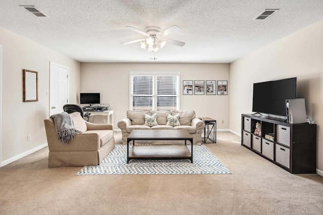 living room with a ceiling fan, visible vents, and light carpet