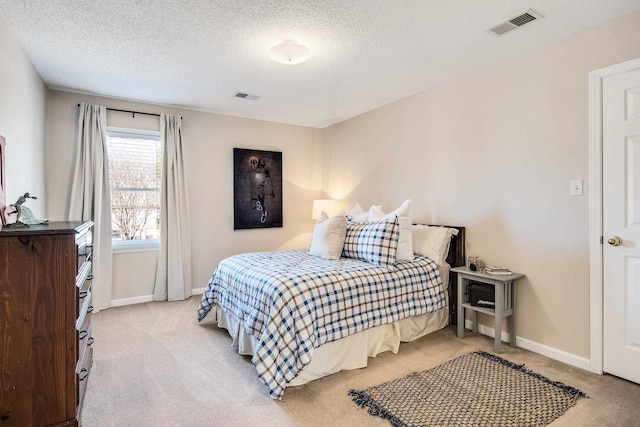 bedroom with visible vents, light carpet, and baseboards