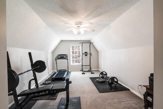 workout area featuring baseboards, a ceiling fan, vaulted ceiling, a textured ceiling, and carpet floors