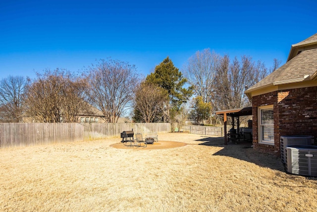 view of yard with a patio area, a fenced backyard, and central air condition unit