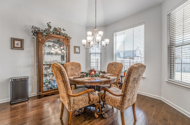 dining space featuring a chandelier, dark wood-style flooring, a wealth of natural light, and baseboards