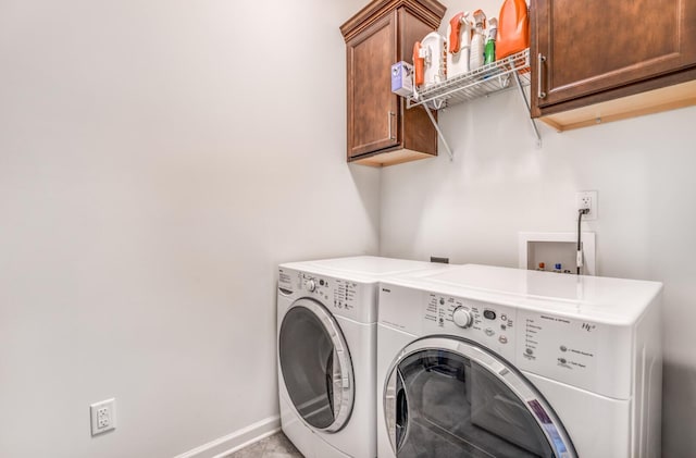 laundry room with washing machine and clothes dryer, cabinet space, and baseboards