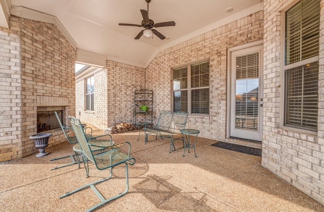 view of patio / terrace featuring an outdoor brick fireplace and ceiling fan