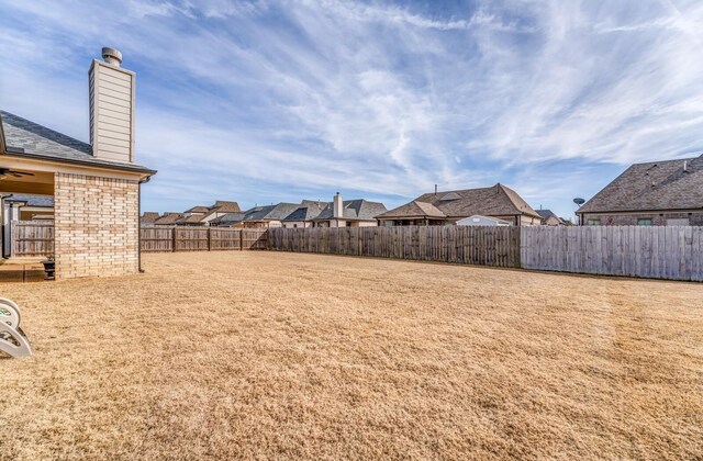 view of yard featuring a fenced backyard and a residential view