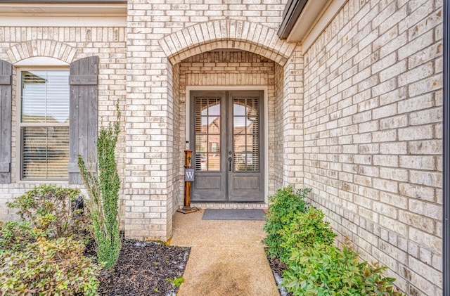 doorway to property featuring french doors and brick siding