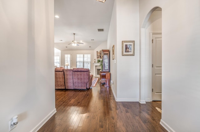 corridor featuring dark wood-type flooring, visible vents, and baseboards