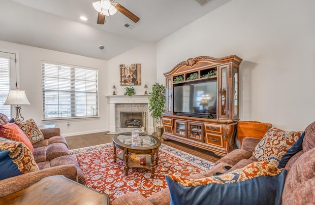 living room featuring lofted ceiling, ceiling fan, a fireplace, wood finished floors, and visible vents