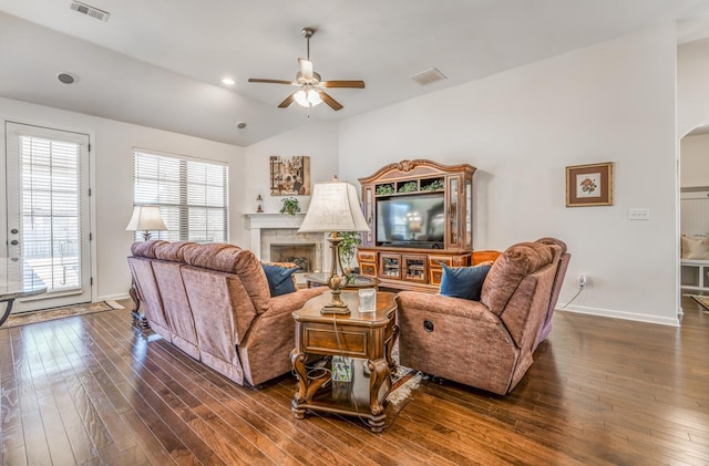 living area with vaulted ceiling, dark wood-style flooring, a fireplace, and visible vents