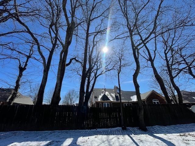 yard layered in snow with fence