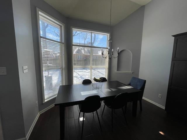 dining room with an inviting chandelier, baseboards, and dark wood-type flooring