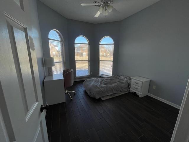 bedroom featuring dark wood-style flooring, a ceiling fan, and baseboards