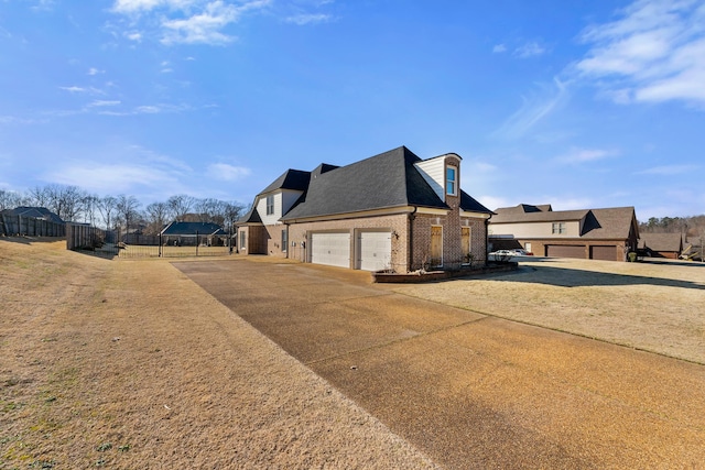 view of side of home with a garage, a residential view, brick siding, and fence