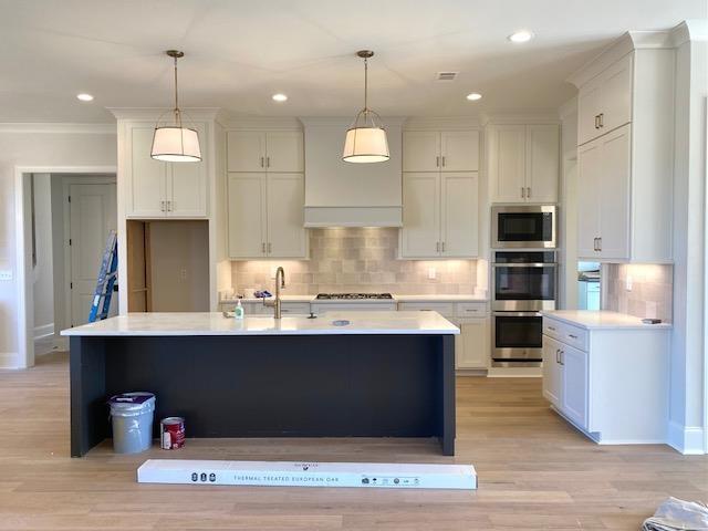 kitchen featuring stainless steel appliances, a sink, light countertops, and decorative backsplash