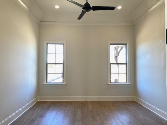 unfurnished room with dark wood-style flooring, a healthy amount of sunlight, and baseboards