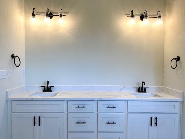 bathroom with a sink and double vanity