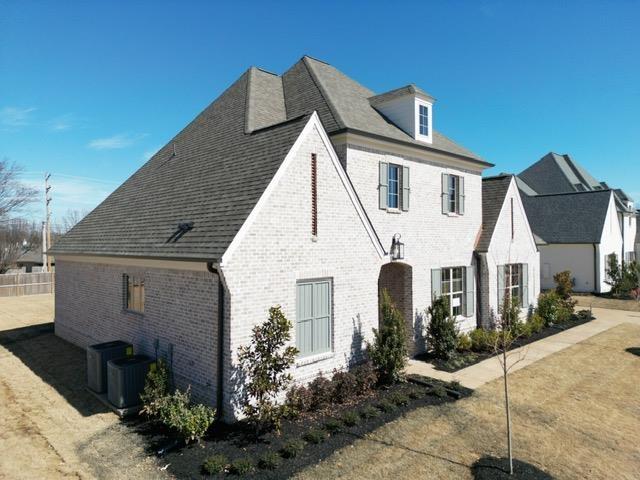 view of front of home with brick siding and central AC unit