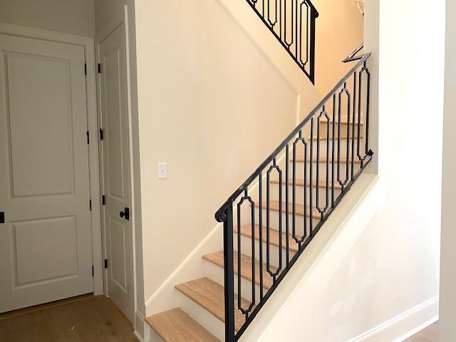 staircase with baseboards and wood finished floors