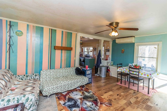 living room with a ceiling fan, ornamental molding, an AC wall unit, and wood finished floors