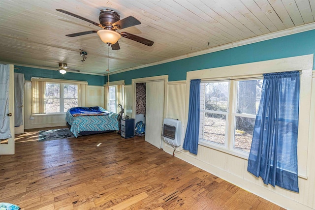 bedroom with crown molding, heating unit, wood ceiling, ceiling fan, and hardwood / wood-style floors