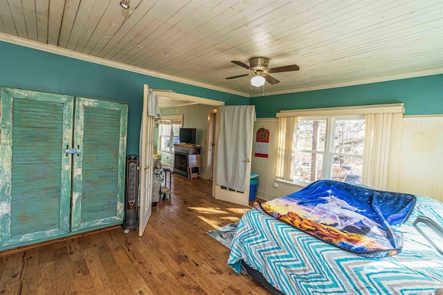 bedroom with multiple windows, ornamental molding, and wood finished floors