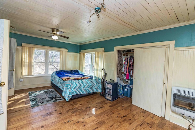 bedroom with ornamental molding, wooden ceiling, heating unit, and wood finished floors