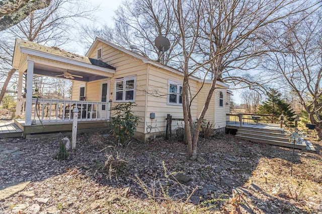 view of side of home with a ceiling fan and a deck