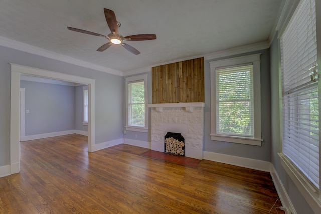 unfurnished living room with a fireplace, baseboards, crown molding, and wood finished floors