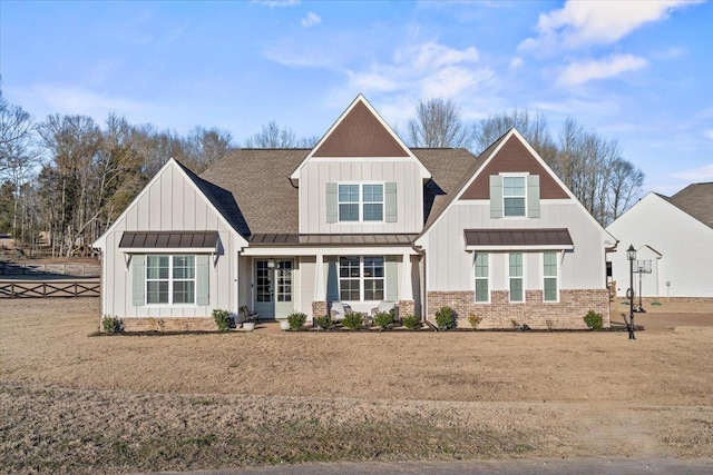 view of front of home with board and batten siding, a standing seam roof, brick siding, and a shingled roof