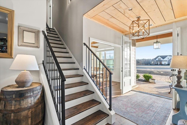 foyer entrance featuring stairway, wood finished floors, and wood ceiling