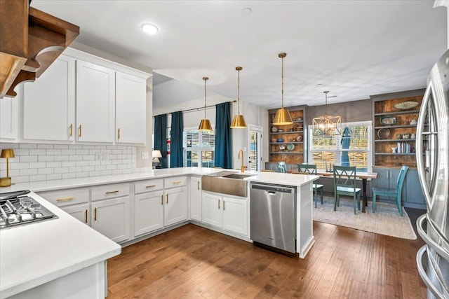 kitchen featuring dark wood-style flooring, light countertops, appliances with stainless steel finishes, white cabinets, and a sink