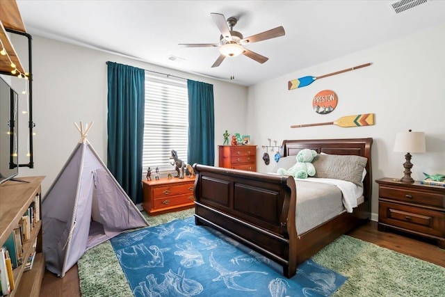 bedroom featuring wood finished floors, visible vents, and a ceiling fan