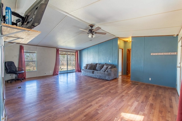 unfurnished living room featuring ceiling fan, vaulted ceiling, and wood finished floors